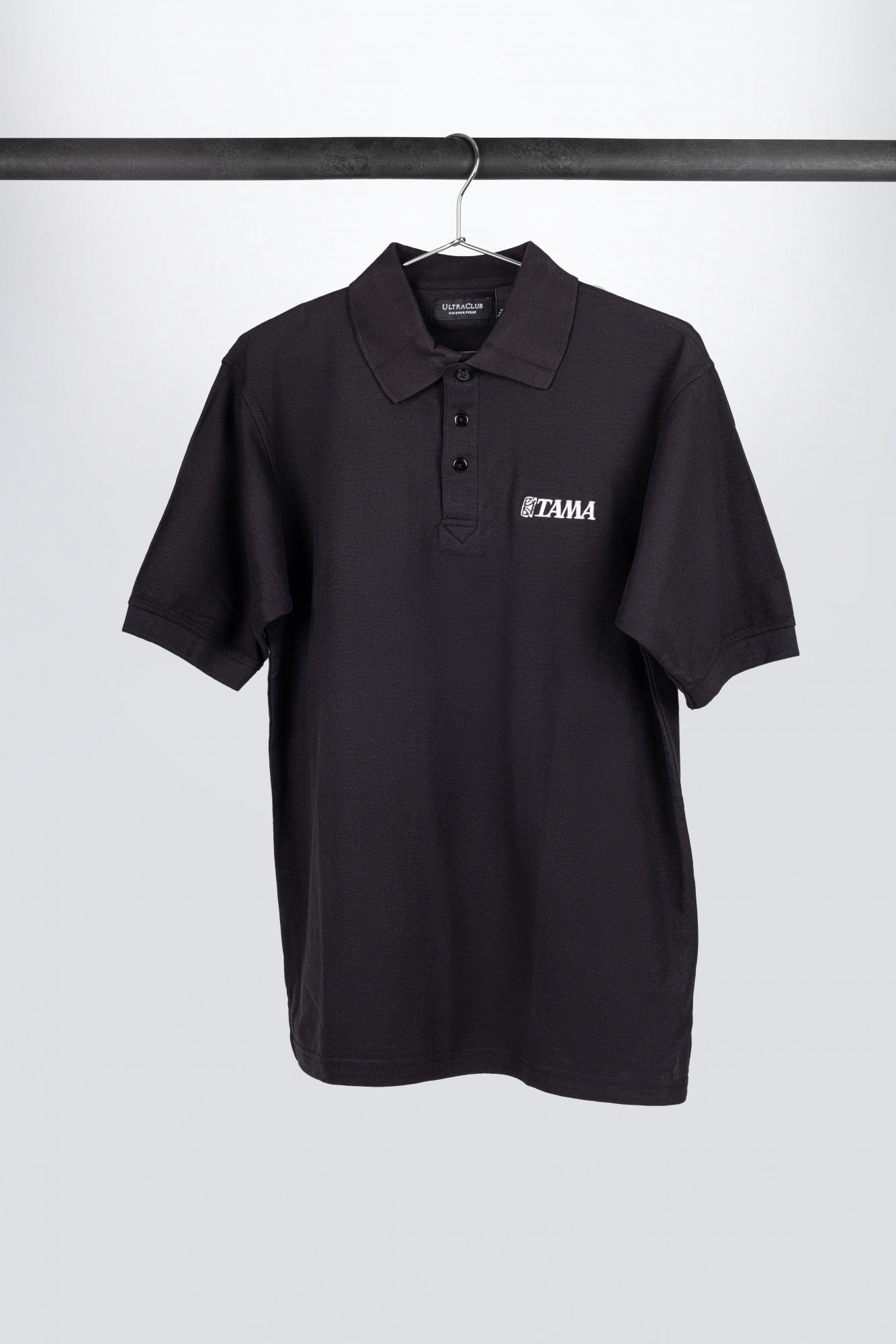 TAMA Polo-Shirt in schwarz mit weiß aufgenähtem Logo auf der Brust